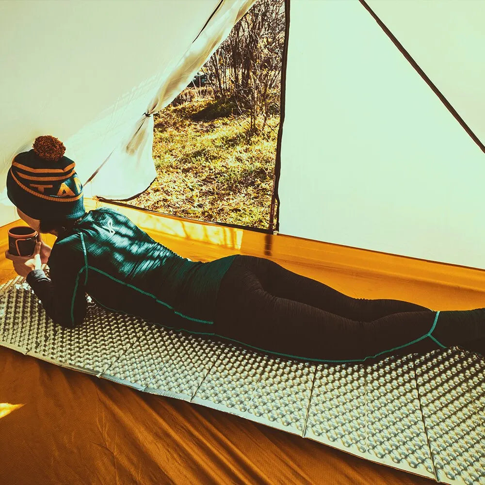 femme sur matelas de sol dans tente