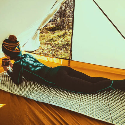 femme sur matelas de sol dans tente