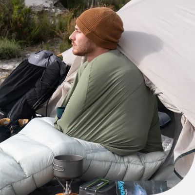 homme assis dans drap de sac de couchage